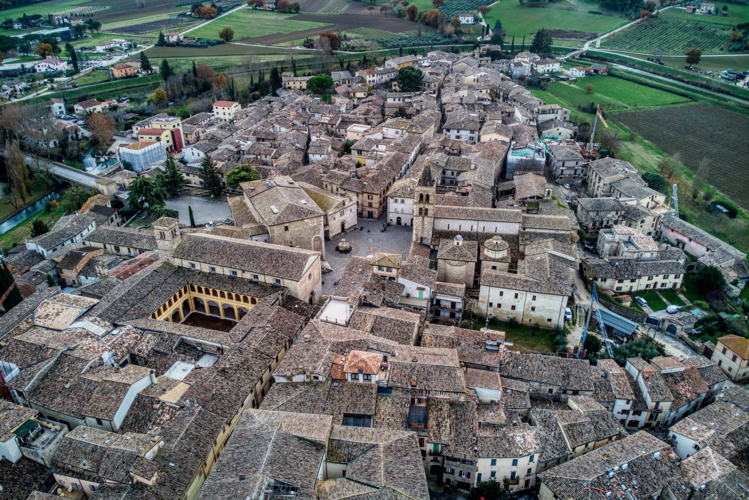 Bevagna vista dall'alto: la piazza, i tetti in cotto e i campi intorno al borgo