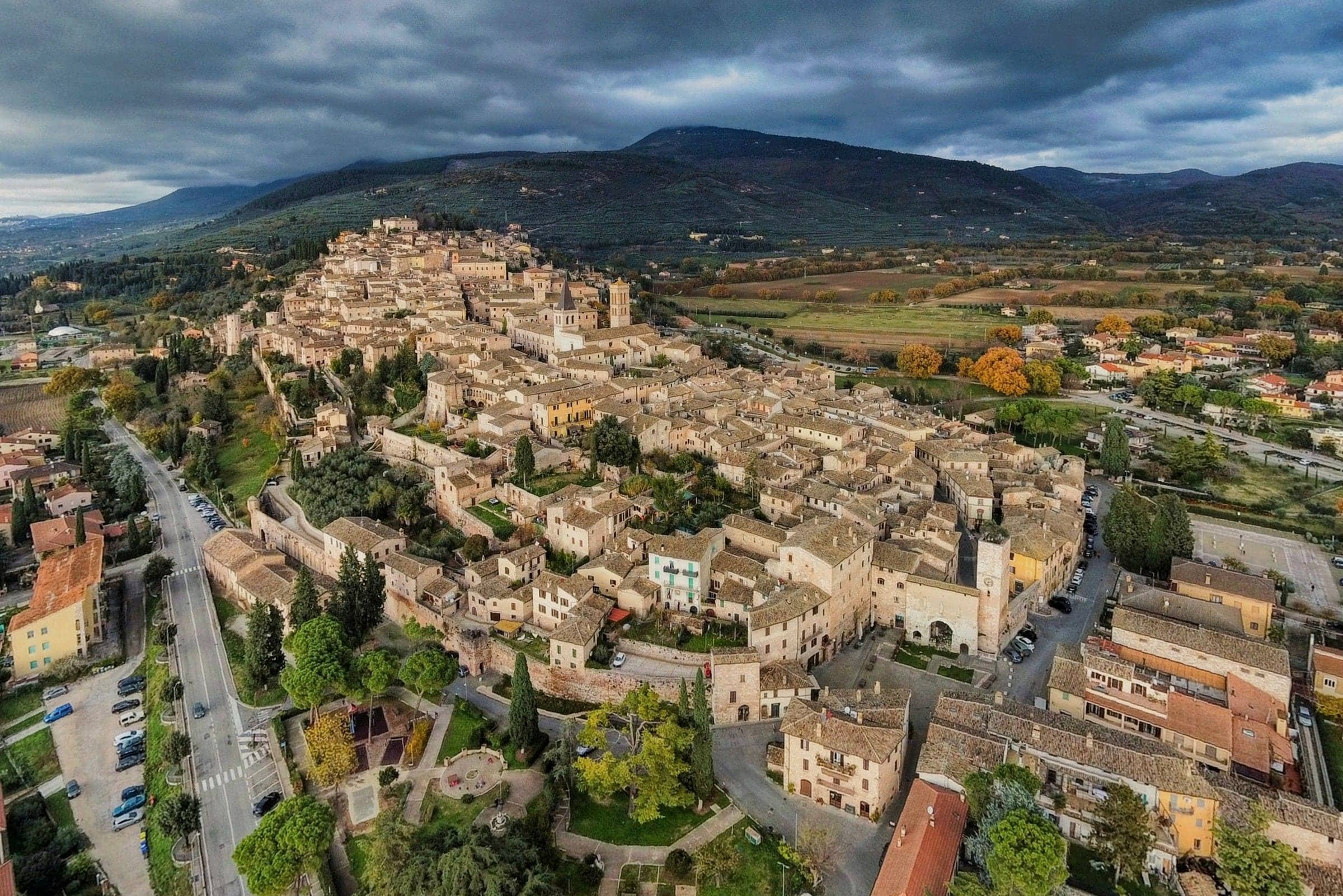 Spello sulla collina, vista dall'alto, con le montagne e la campagna intorno